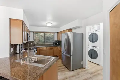 a kitchen with a stainless steel refrigerator and a sink at Shaver Escape Hot Tub Cabin Retreat with AC in Shaver Lake
