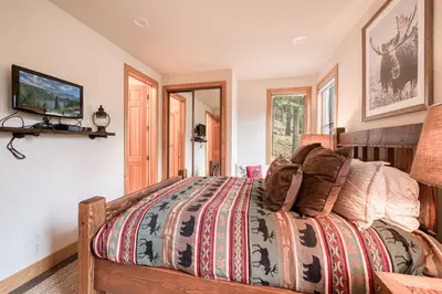 a bedroom with a bed with a comforter on it at Easy Living at Northstar by Tahoe Getaways - 4BR Pet Friendly w/ Ski Shuttle & HOA in Truckee