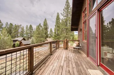 a wooden deck with a chair on a house at Easy Living at Northstar by Tahoe Getaways - 4BR Pet Friendly w/ Ski Shuttle & HOA in Truckee