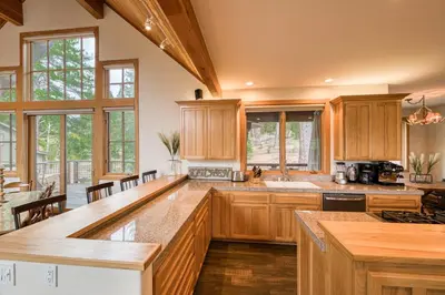 a large kitchen with wooden cabinets and a large island at Easy Living at Northstar by Tahoe Getaways - 4BR Pet Friendly w/ Ski Shuttle & HOA in Truckee