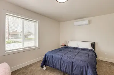 a bedroom with a bed and a window at Under 1 Mi to Med Center! Stylish Home in Tulare in Tulare
