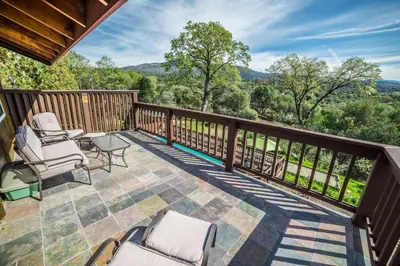a patio with chairs and a table on a deck at Nature's Inn Bed and Breakfast in Ahwahnee
