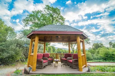 a gazebo with two chairs and a table at Nature's Inn Bed and Breakfast in Ahwahnee
