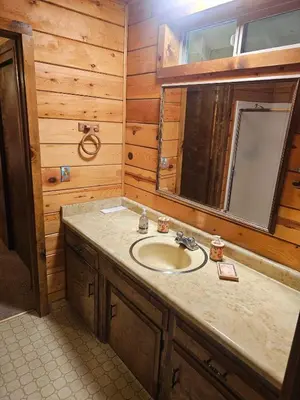 a bathroom with a sink and a mirror at The Cozy Knotty Pine Enchantment Retreat in Long Barn