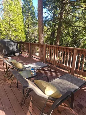 a wooden deck with a table and chairs on it at The Cozy Knotty Pine Enchantment Retreat in Long Barn