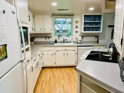 a kitchen with white cabinets and a white refrigerator at Cozy Riverfront Home with EV charger in Three Rivers