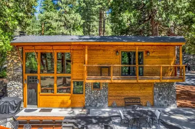 a log cabin with a porch and a deck at Little Bridge Lodge Stateline - Small Dogs Ok in Stateline
