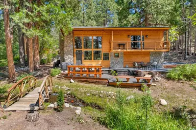 a cabin in the woods with a bridge and a house at Little Bridge Lodge Stateline - Small Dogs Ok in Stateline