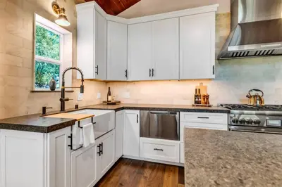 a kitchen with white cabinets and a sink at Little Bridge Lodge Stateline - Small Dogs Ok in Stateline