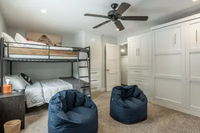 a bedroom with a bunk bed and two blue chairs at Luxury Helios Retreat by the Village- Apres Ready in Mammoth Lakes