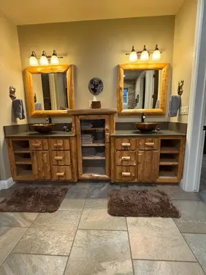 a bathroom with two sinks and two mirrors at Yosemite's Inn the Woods in Ahwahnee