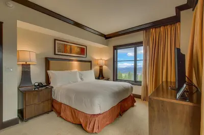 a bedroom with a bed and a tv and a window at Northstar Ritz-Carlton in Truckee