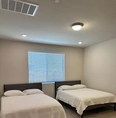 two beds in a room with a window at Prime Location Residence in Manteca