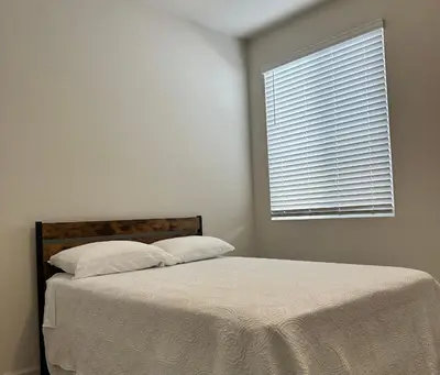 a bed with two pillows and a window in a bedroom at Prime Location Residence in Manteca