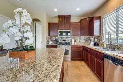a kitchen with wooden cabinets and a counter top at Sophisticated Sanctuary 8 Mi to Lodi Wineries! in Stockton