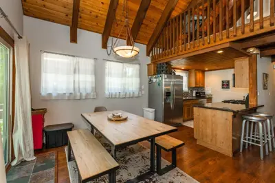 a large kitchen with a wooden table and a counter at Alder Creek Paradise Tree-lined Cabin Stay for 7 in Truckee