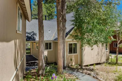a house with a fence and trees in front of it at Alder Creek Paradise Tree-lined Cabin Stay for 7 in Truckee