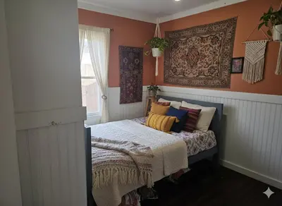 a bedroom with orange walls and a bed with pillows at La Lomas Bohemian Courtyard Cottage in Modesto