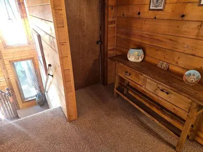 a room with a wooden wall with a wooden dresser at Peaceful Mountain Cabin with Private Lake and Game Room Near Long Barn, California in Long Barn