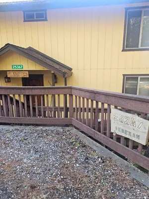 a house with a wooden fence in front of it at Peaceful Mountain Cabin with Private Lake and Game Room Near Long Barn, California in Long Barn