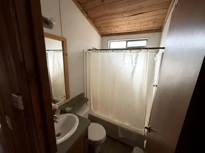 a bathroom with a shower curtain and a sink at Cozy Mountain-Style Cabin with Scenic Sierra Nevada Views Near Lone Pine, California in Lone Pine