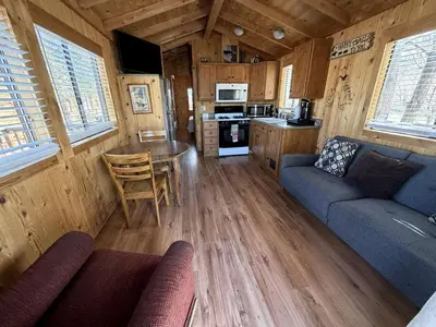 a living room with a couch and a table in a cabin at Cozy Mountain-Style Cabin with Scenic Sierra Nevada Views Near Lone Pine, California in Lone Pine