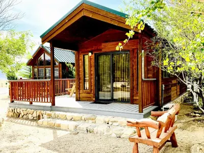 a wooden cabin with a bench in front of it at Cozy Mountain-Style Cabin with Scenic Sierra Nevada Views Near Lone Pine, California in Lone Pine
