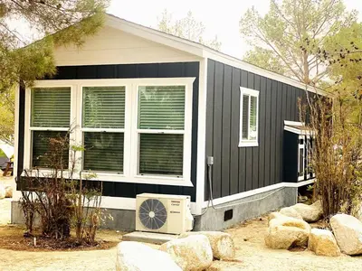 a black house with a fan in front of it at Modern Tiny Home with Mountain Views Near Mt. Whitney, Lone Pine, California in Lone Pine
