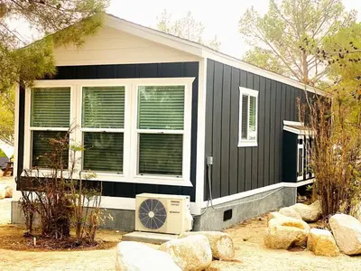 a black house with a fan in front of it at Modern Tiny Home with Mountain Views Near Mt. Whitney, Lone Pine, California in Lone Pine