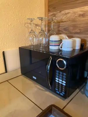 a microwave with cups and wine glasses on top of it at St Annas House in Squaw Valley