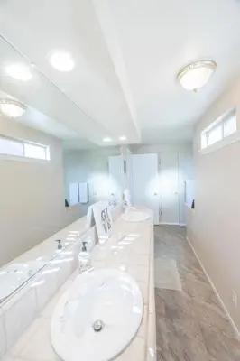 a white bathroom with three sinks and mirrors at St Annas House in Squaw Valley