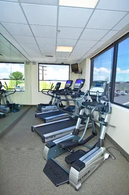 a gym with several tread machines in a room at Carson Valley Inn in Minden