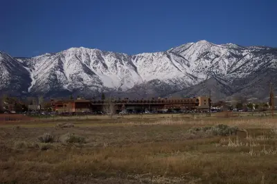 a mountain range with snow covered mountains behind a building at Carson Valley Inn in Minden