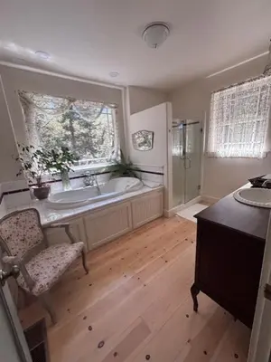 a bathroom with a tub and a chair and a window at The Firehouse Inn-Cottage in Mariposa