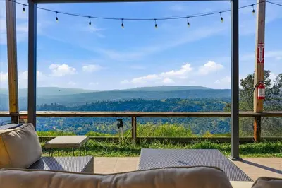 a living room with a couch and a view of the mountains at Incredible View Near Yosemite, Spacious 4BR House! in Coarsegold