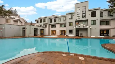 a large swimming pool in front of a building at The Ridgeline by AvantStay Shared Pool Hot Tub Sauna Ski-In Access Village Walk in Olympic Valley