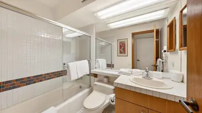 a bathroom with a toilet and a sink and a tub at The Traverse by AvantStay Ski-InSki-Out Condo • Pool Hot Tub Access • Steps to KT-22 in Olympic Valley