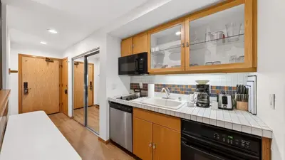 a kitchen with wooden cabinets and a sink at The Traverse by AvantStay Ski-InSki-Out Condo • Pool Hot Tub Access • Steps to KT-22 in Olympic Valley
