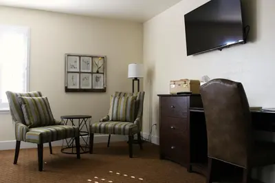 a room with two chairs and a dresser and a television at Rest, a boutique hotel in Plymouth