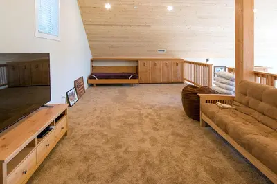 a large living room with a couch and a tv at River Rock Retreat in Yosemite West