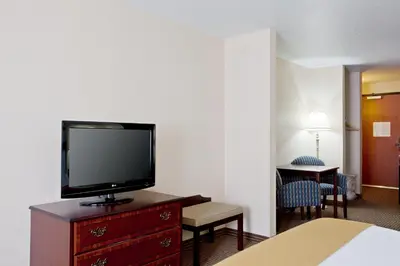 a hotel room with a flat screen tv on a dresser at Holiday Inn Express & Suites Jackson by IHG in Jackson