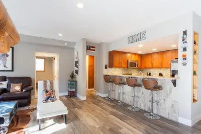 a living room with a kitchen and a bar with stools at Snowcreek #881 - Phase V in Mammoth Lakes