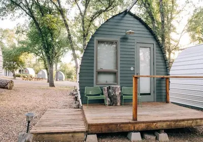 a green tiny house with a wooden deck at Sierra Meadows in Ahwahnee