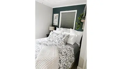 a bedroom with a bed and a green accent wall at Lazy Z Resort in Twain Harte