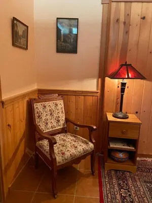 a room with a chair and a table with a lamp at Sierra Trails Inn in Mariposa