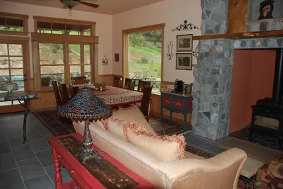 a living room with a couch and a stone fireplace at Sierra Trails Inn in Mariposa