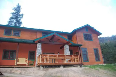 a large wooden house with a large porch at Sierra Trails Inn in Mariposa