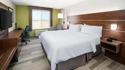 a hotel room with a large bed and a flat screen tv at Holiday Inn Express & Suites Dinuba West by IHG in Dinuba