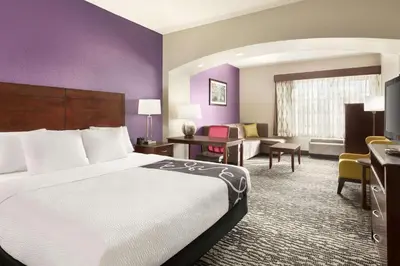 a hotel room with a large bed and a desk at La Quinta by Wyndham Fresno Northwest in Fresno