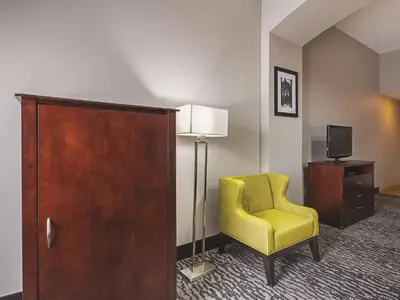 a hotel room with a yellow chair and a tv at La Quinta by Wyndham Fresno Northwest in Fresno